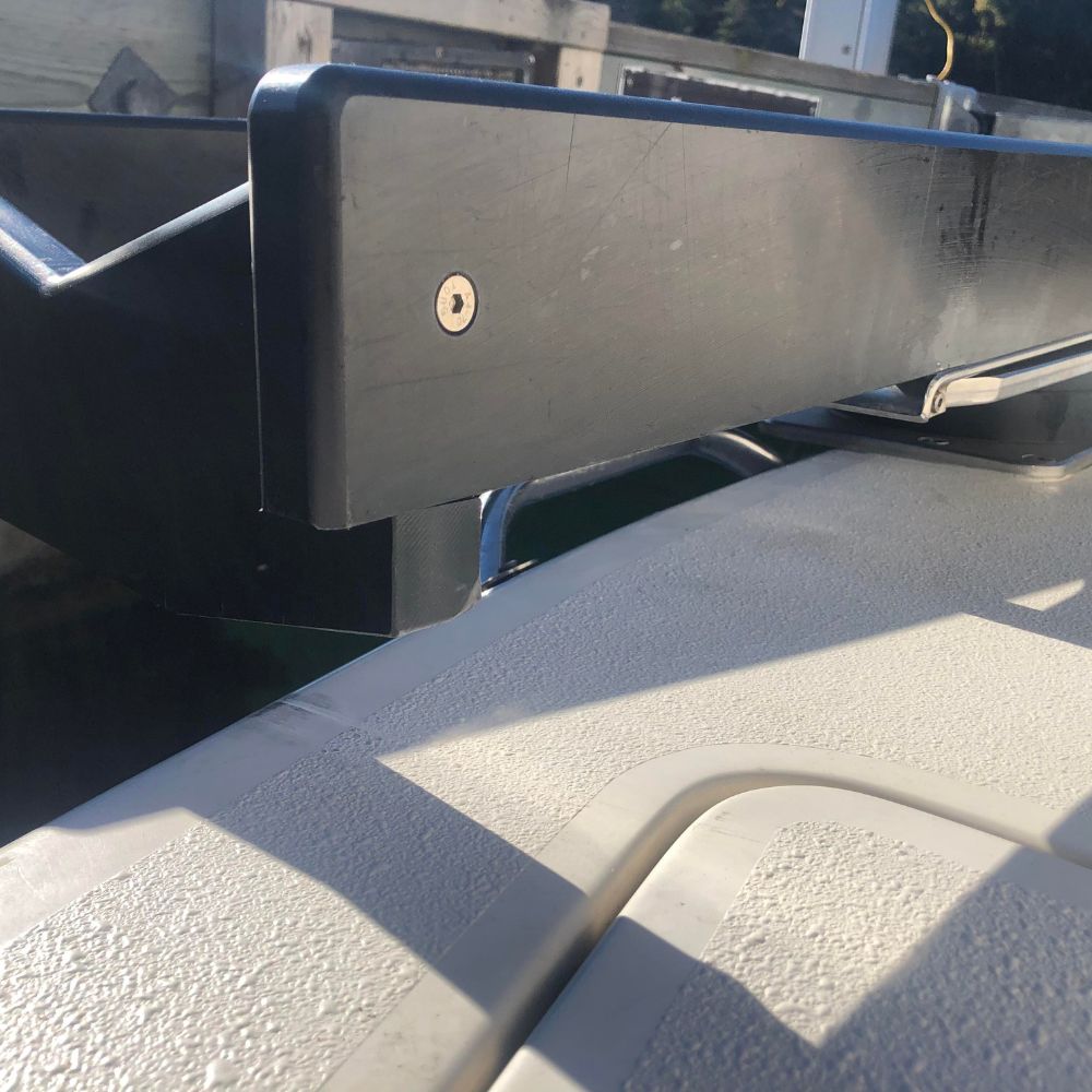 NorDav boat transom swivel plate elevator block providing clean vertical lifting tracks past a thick rub-rail boundary.